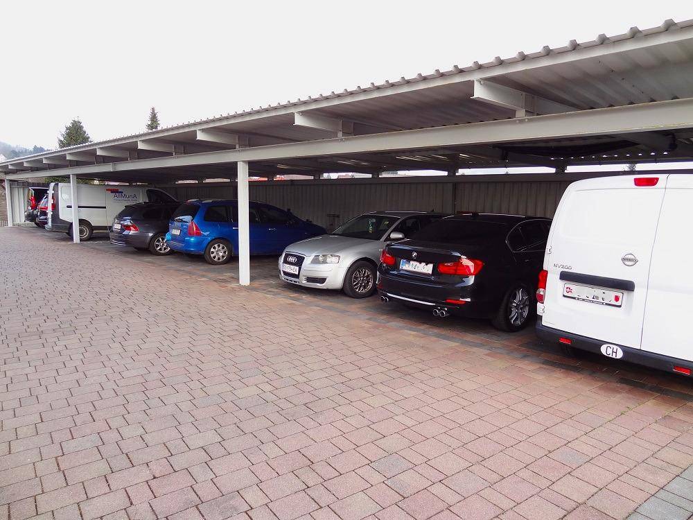 Reihe von Autos unter dem Carport geparkt, die Struktur bietet Schutz vor Witterungseinflüssen.