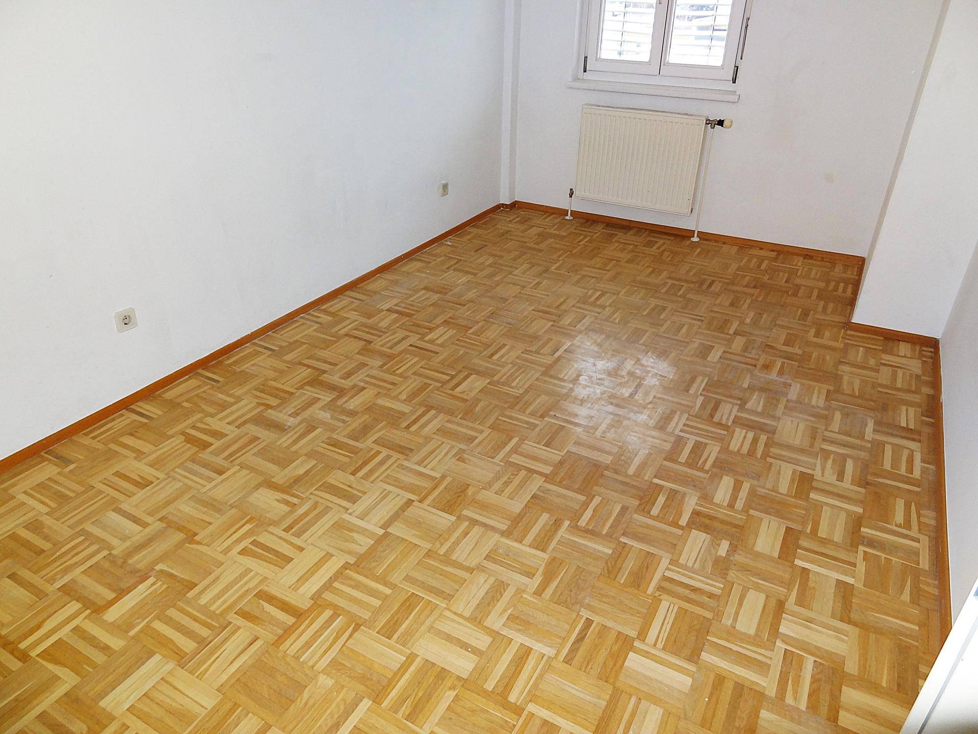 Schlafzimmer mit hellem Parkettboden und weißen Wänden, bereit zur individuellen Gestaltung.