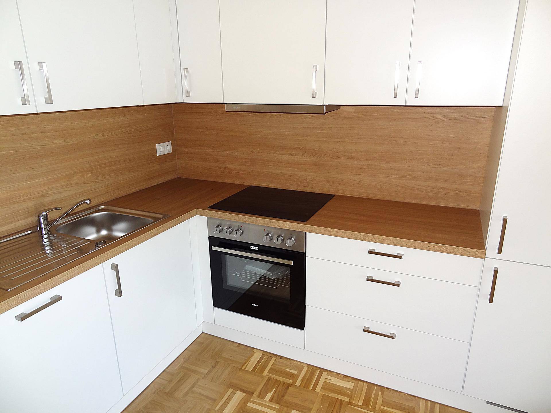 Detailansicht der modernen Küche mit Spüle, Induktionskochfeld und integriertem Backofen.