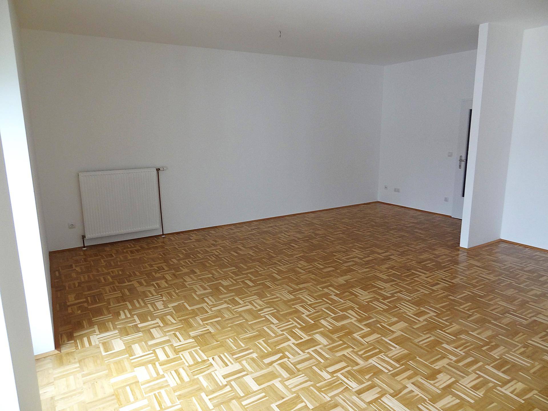Geräumiger Wohnbereich mit Parkettboden und viel Platz für individuelle Gestaltung.