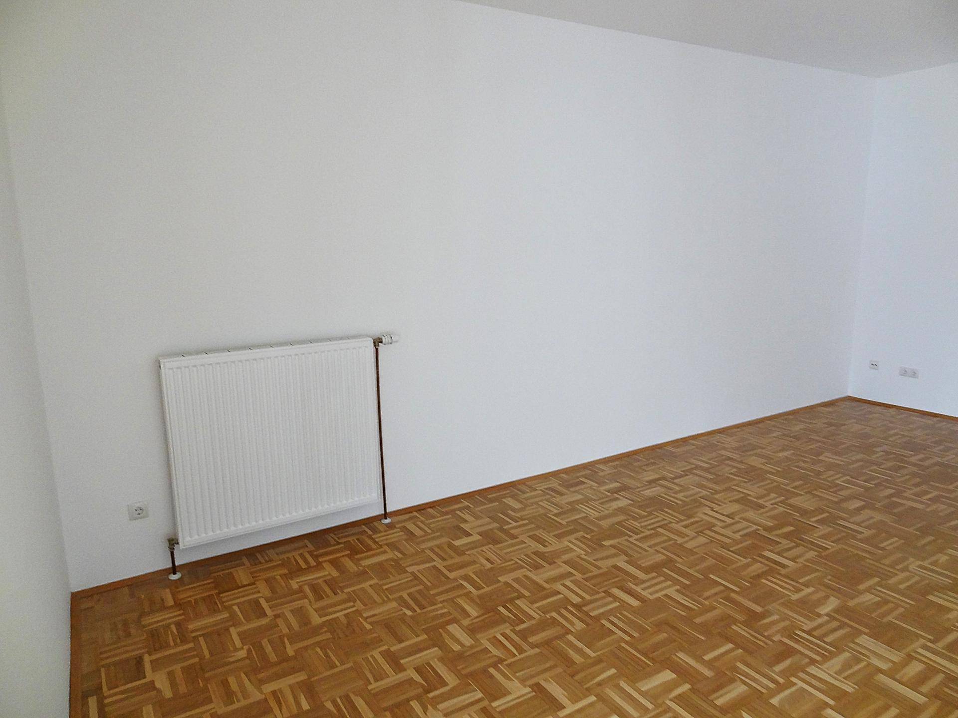 Detailansicht eines weißen Heizkörpers an einer frisch gestrichenen Wand.