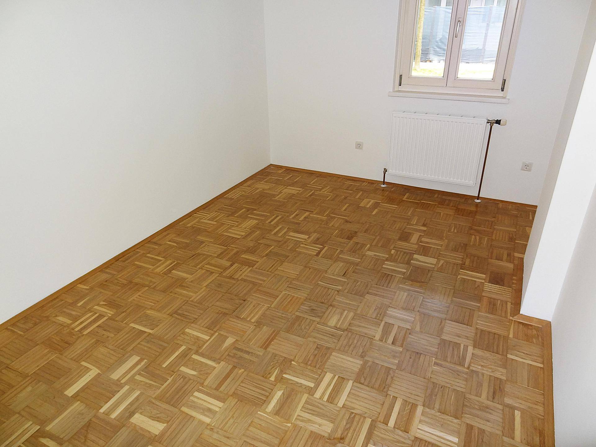 Geräumiges Zimmer mit Parkettboden und weißen Wänden, ideal als Schlaf- oder Arbeitszimmer nutzbar.