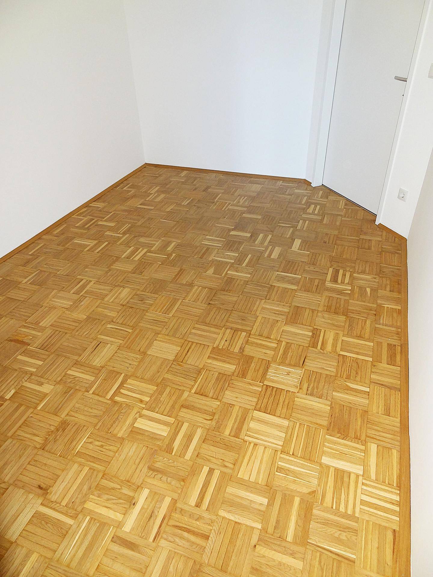 Heller Raum mit Parkettboden und weißen Wänden, bietet vielseitige Nutzungsmöglichkeiten.