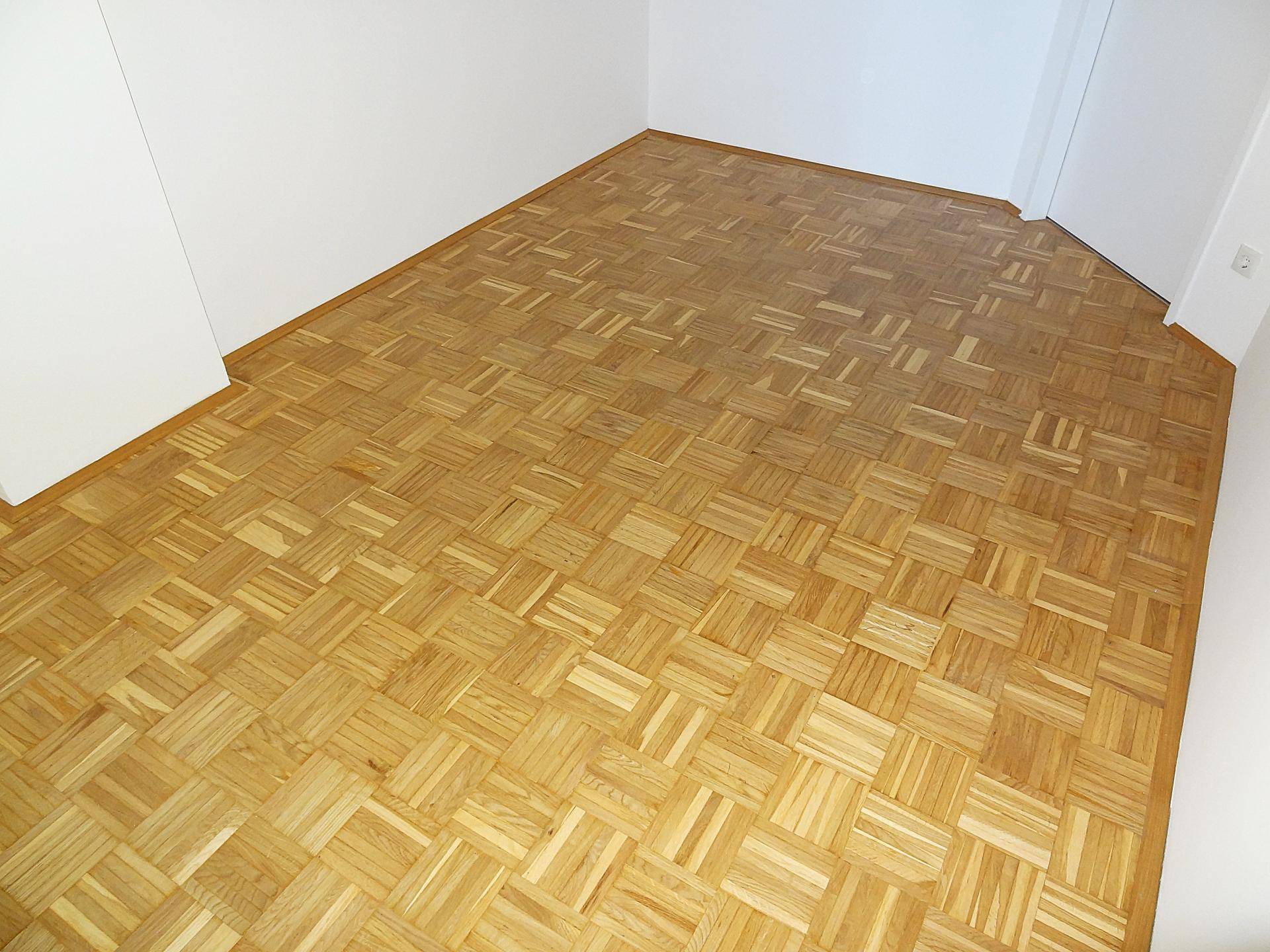 Geräumiges Zimmer mit Parkettboden und weißen Wänden, ideal für Schlaf- oder Arbeitsbereich.