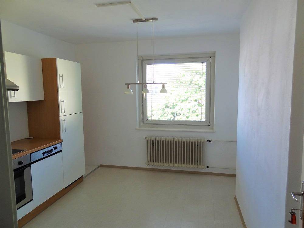 Heller Küchenbereich mit großem Fenster und Heizkörper, ideal für einen kleinen Esstisch.