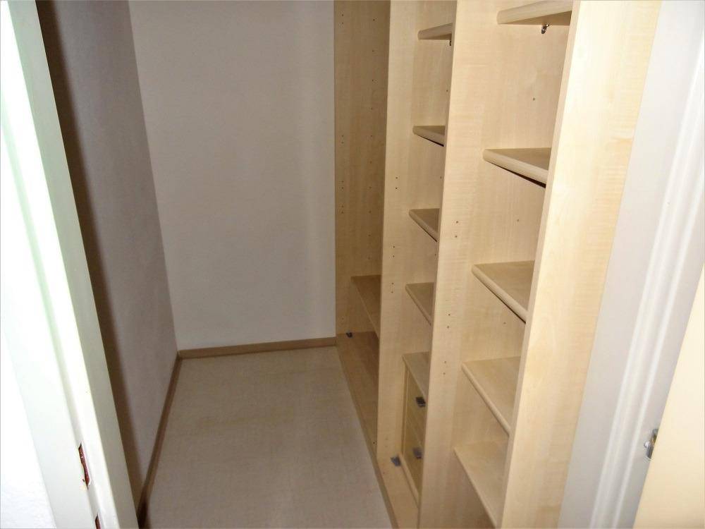 Praktischer Abstellraum mit eingebauten Regalen für zusätzlichen Stauraum.