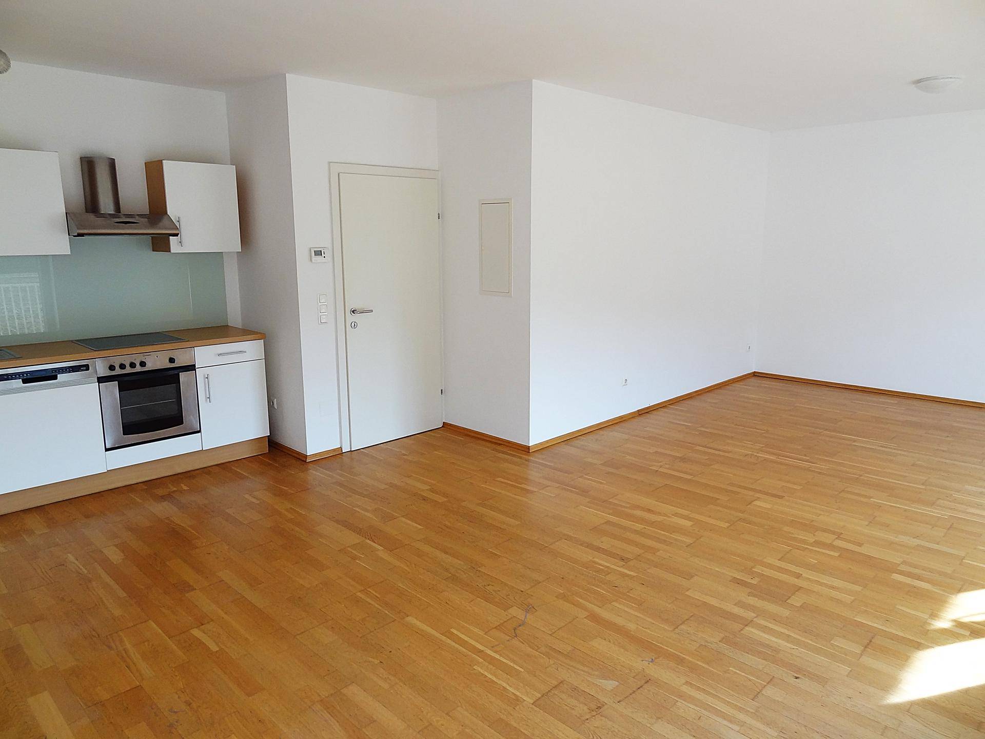 Heller Wohnbereich mit Parkettboden und weißen Wänden, bietet viel Platz für individuelle Einrichtungsideen.