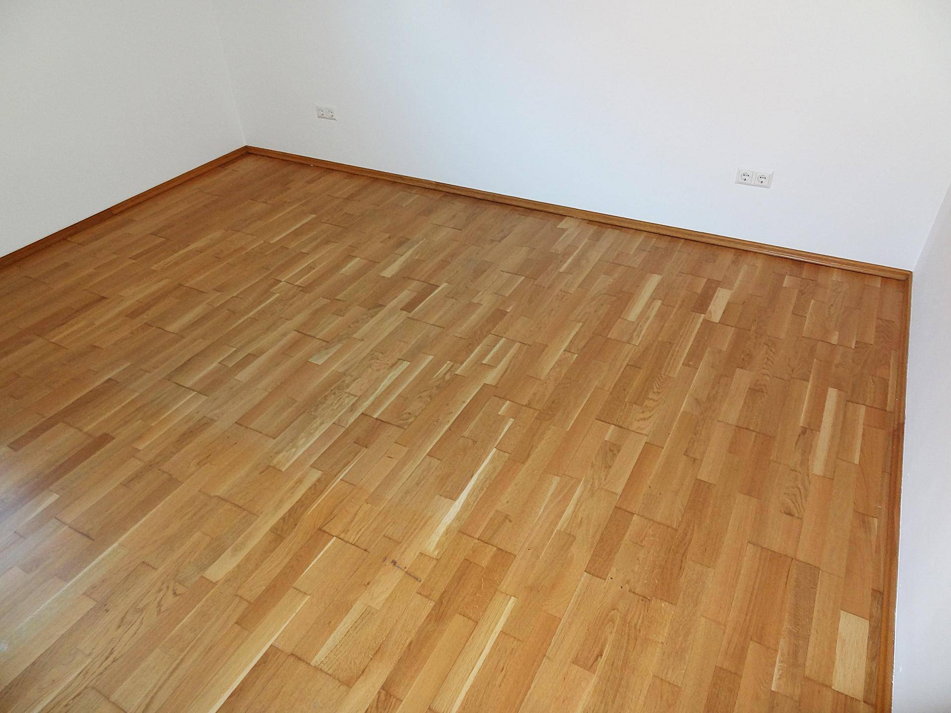 Detailaufnahme des hochwertigen Parkettbodens in einem hellen Innenraum, unterstreicht die Qualität der Ausstattung.