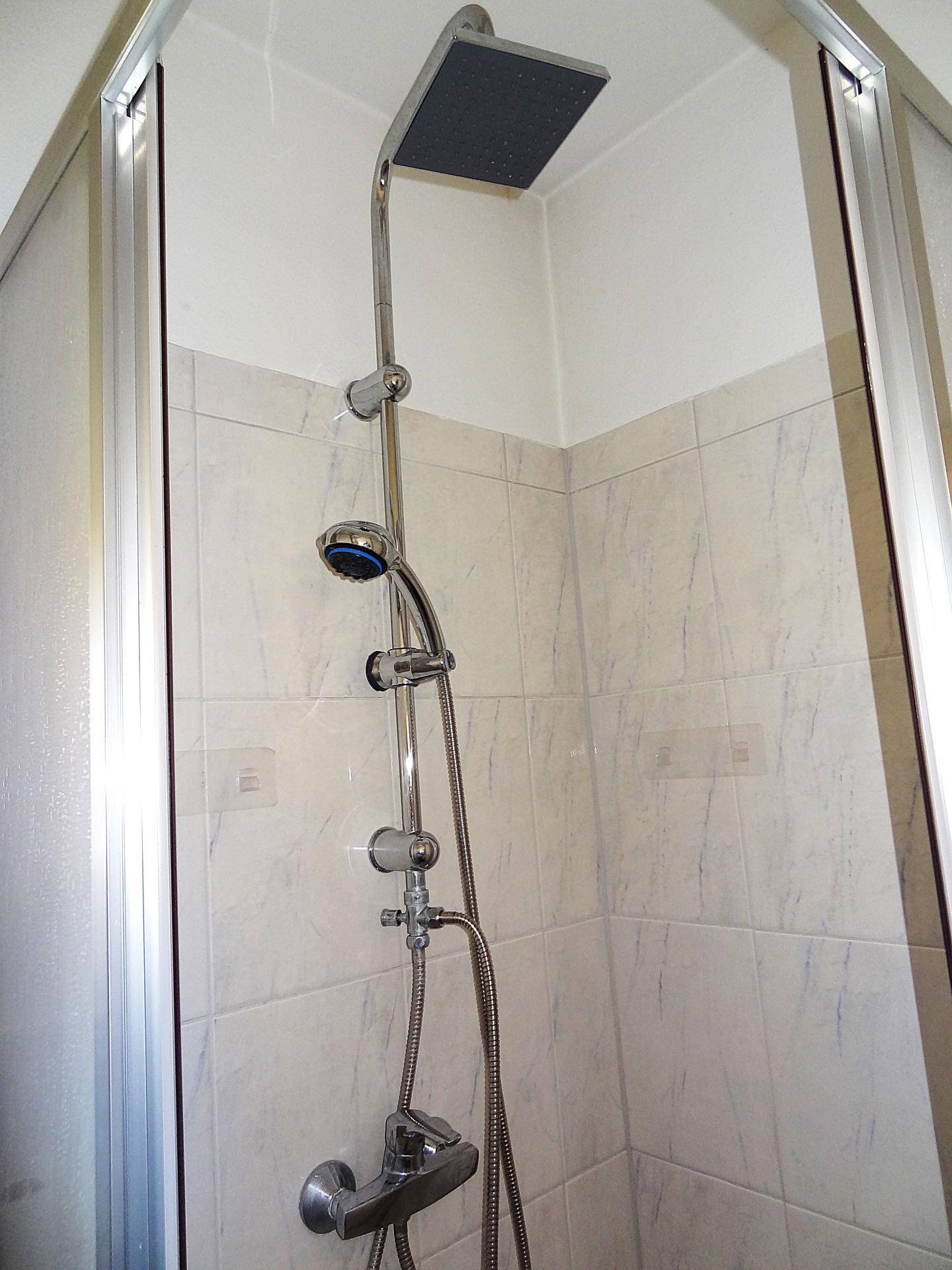 Moderne Regendusche mit Handbrause in der Duschkabine, bietet angenehmen Duschkomfort.