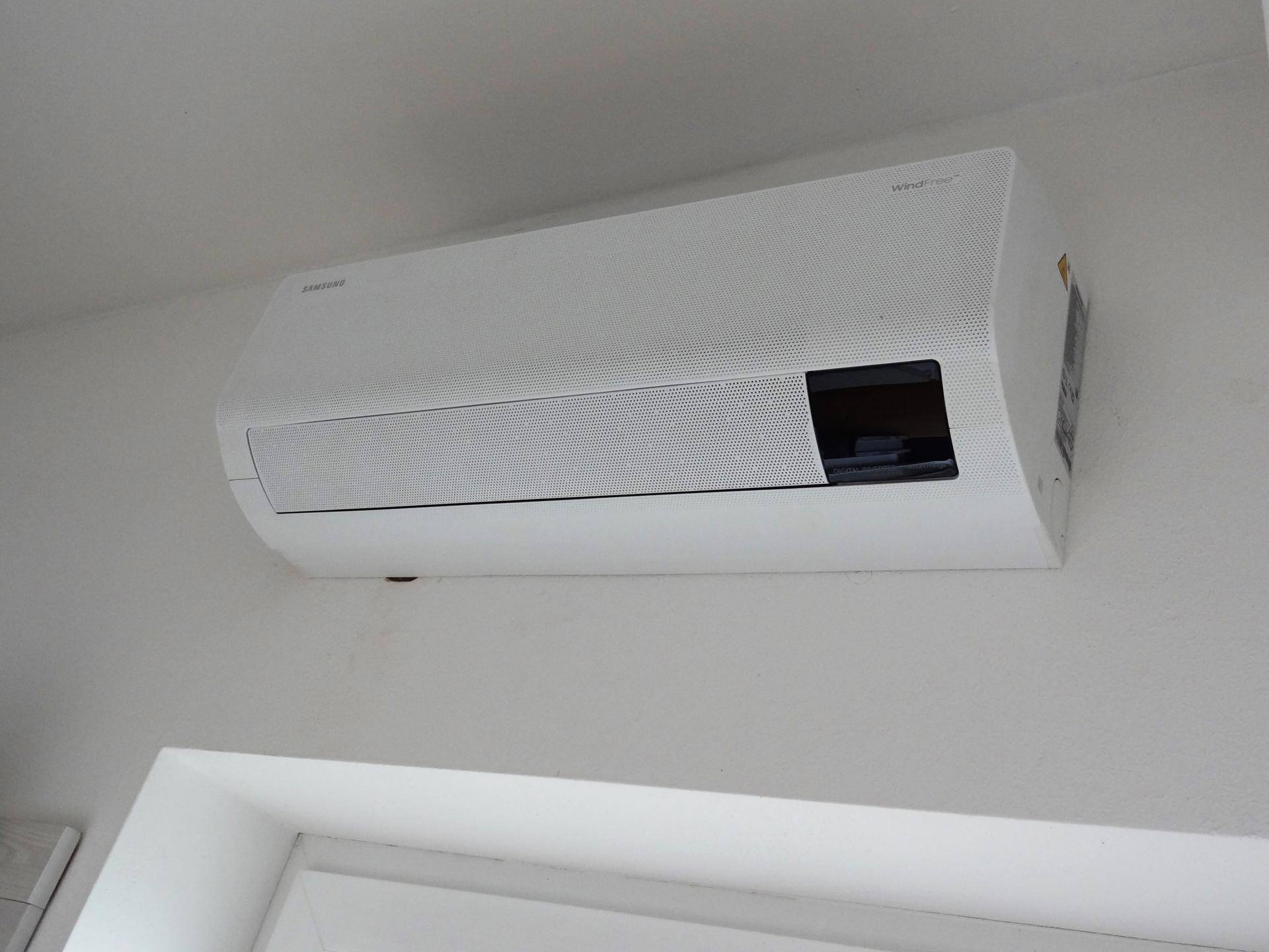 Nahaufnahme einer modernen Klimaanlage an der Wand, die für angenehme Raumtemperaturen sorgt.
