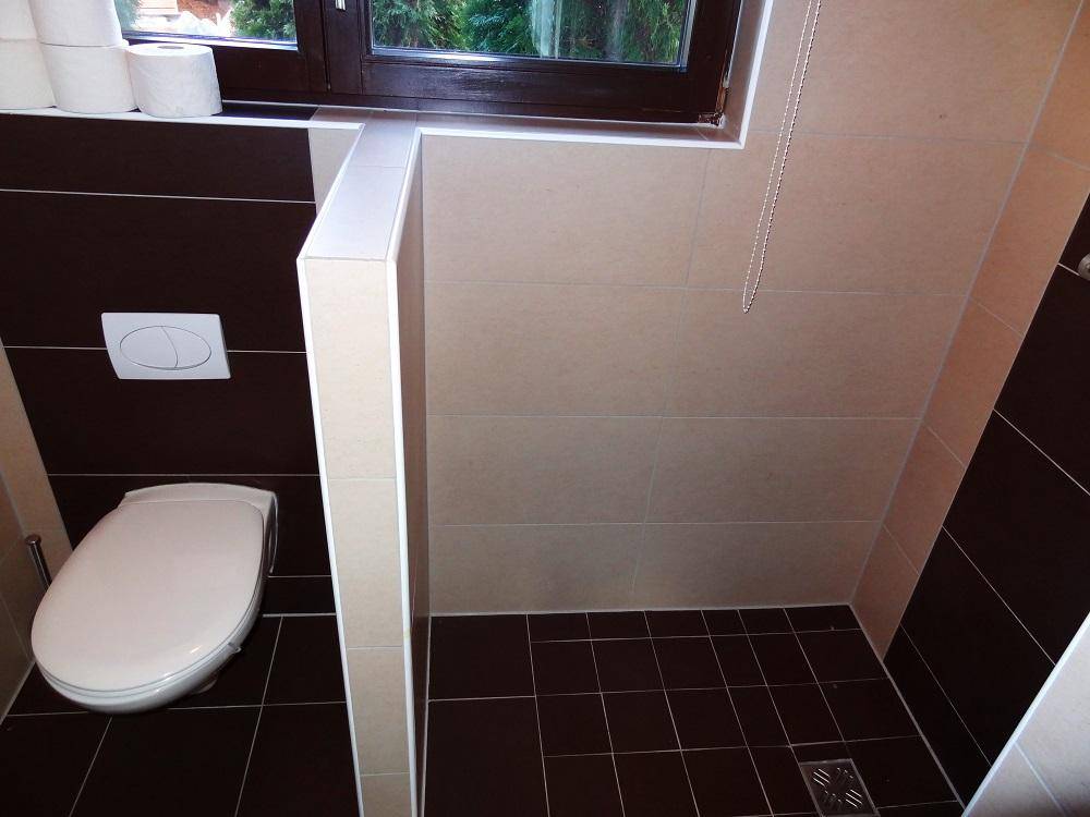 Modernes Badezimmer mit Wand-WC und begehbarer Dusche, gefliest in Braun- und Beigetönen.