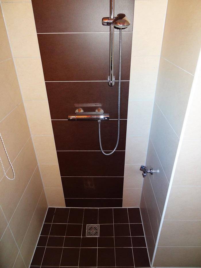 Moderne Duschkabine mit braunen und beigen Fliesen sowie einer Regendusche.