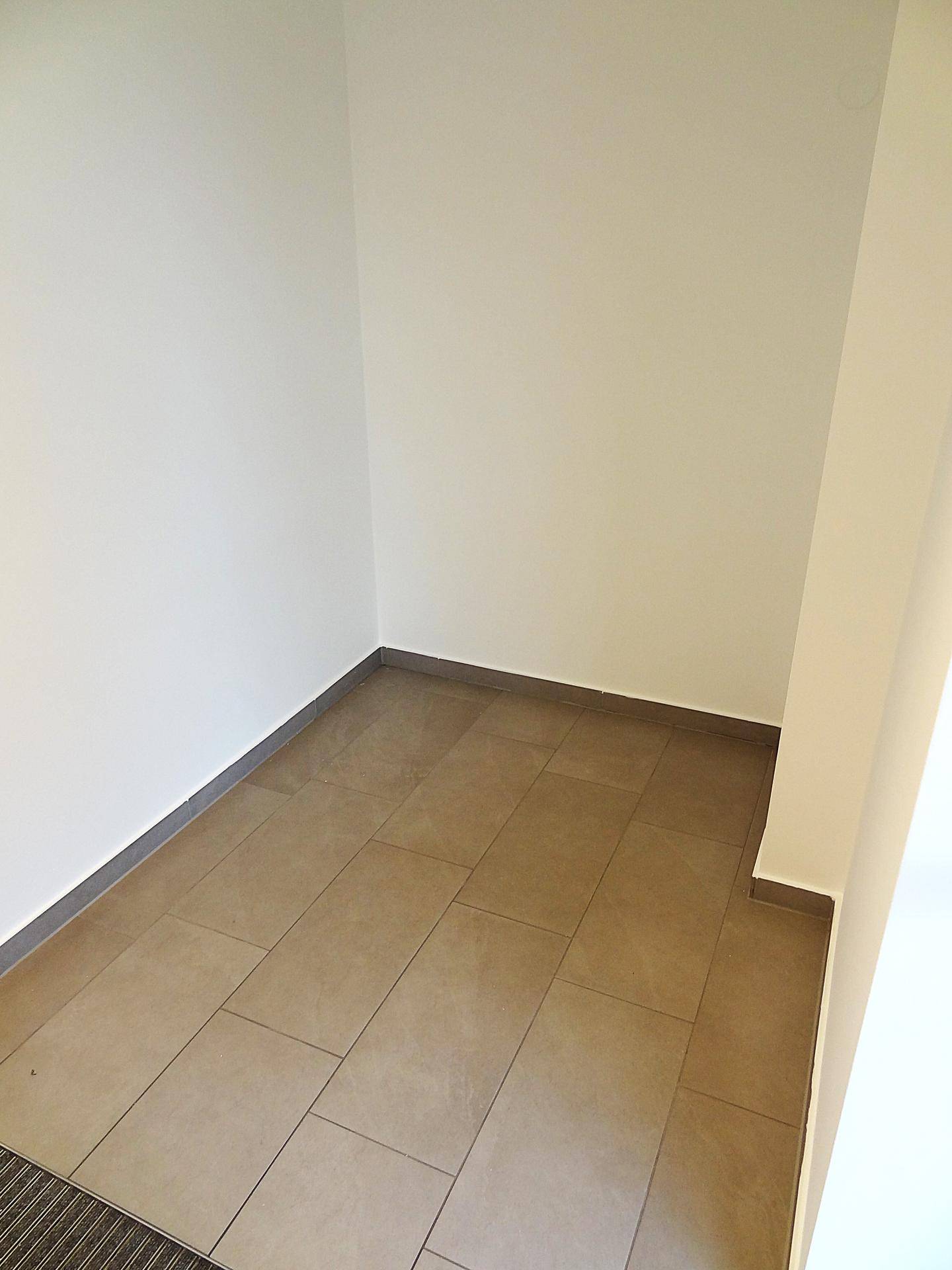 Kleiner, leerer Abstellraum mit Fliesenboden und weißen Wänden, ideal für Lagerzwecke.