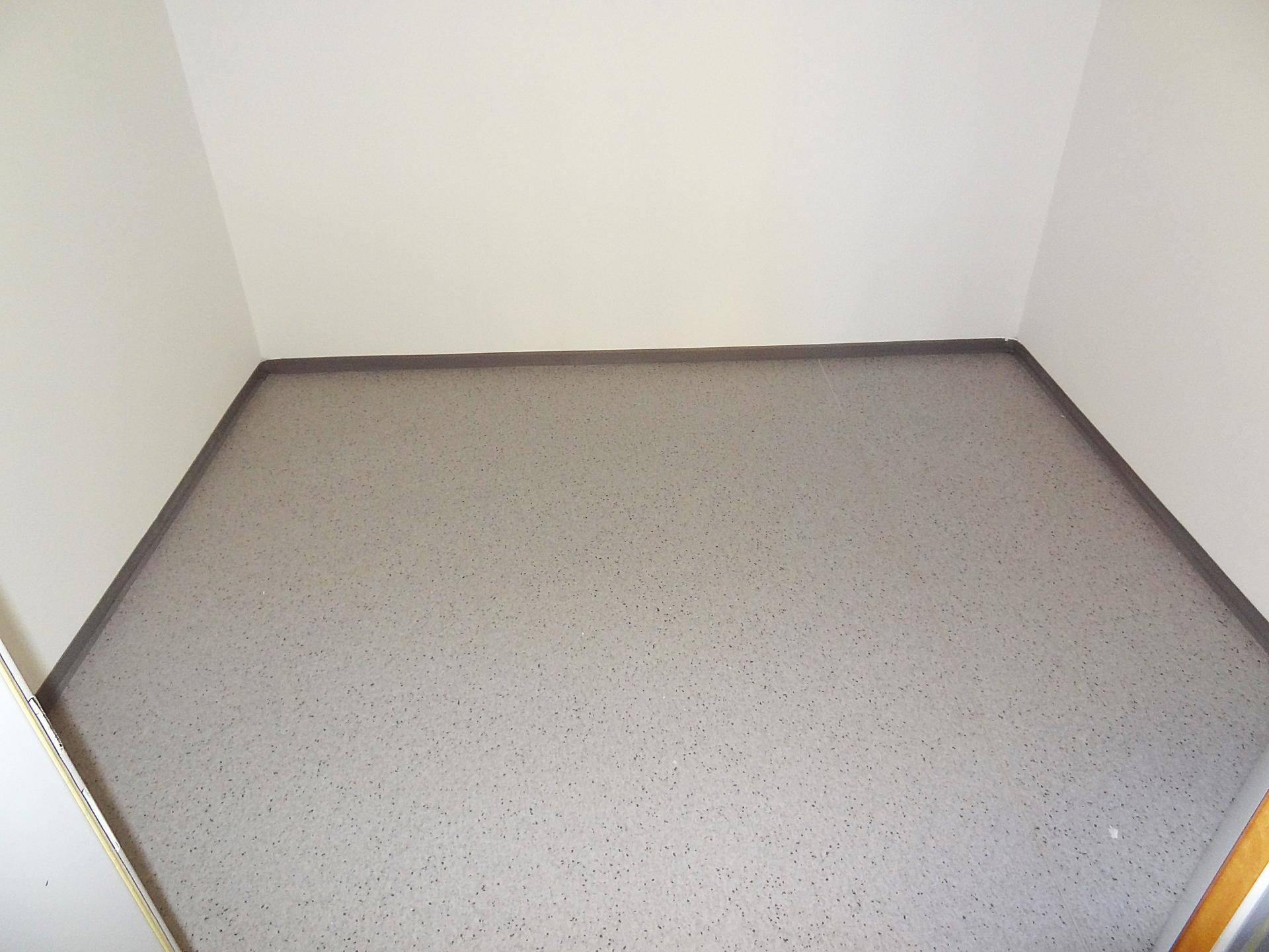 Kleiner, leerer Raum mit grauem Boden und weißen Wänden, ideal als Abstellraum.
