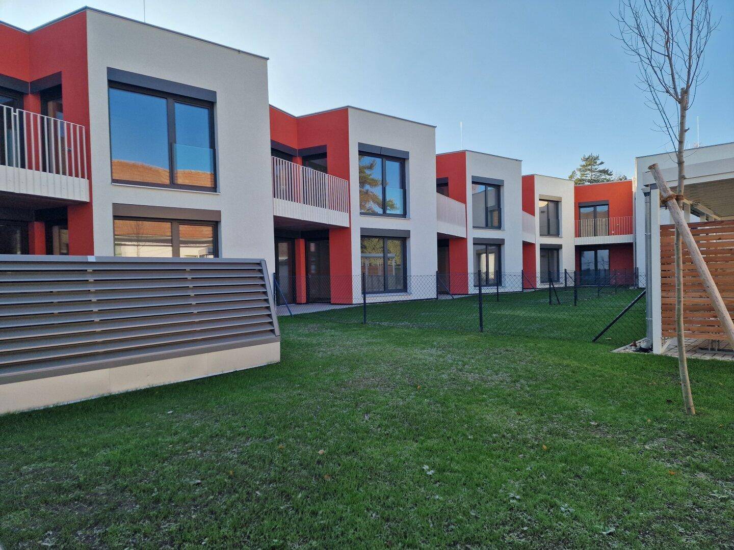 Moderne Wohnanlage mit gepflegten Rasenflächen und klaren architektonischen Linien.