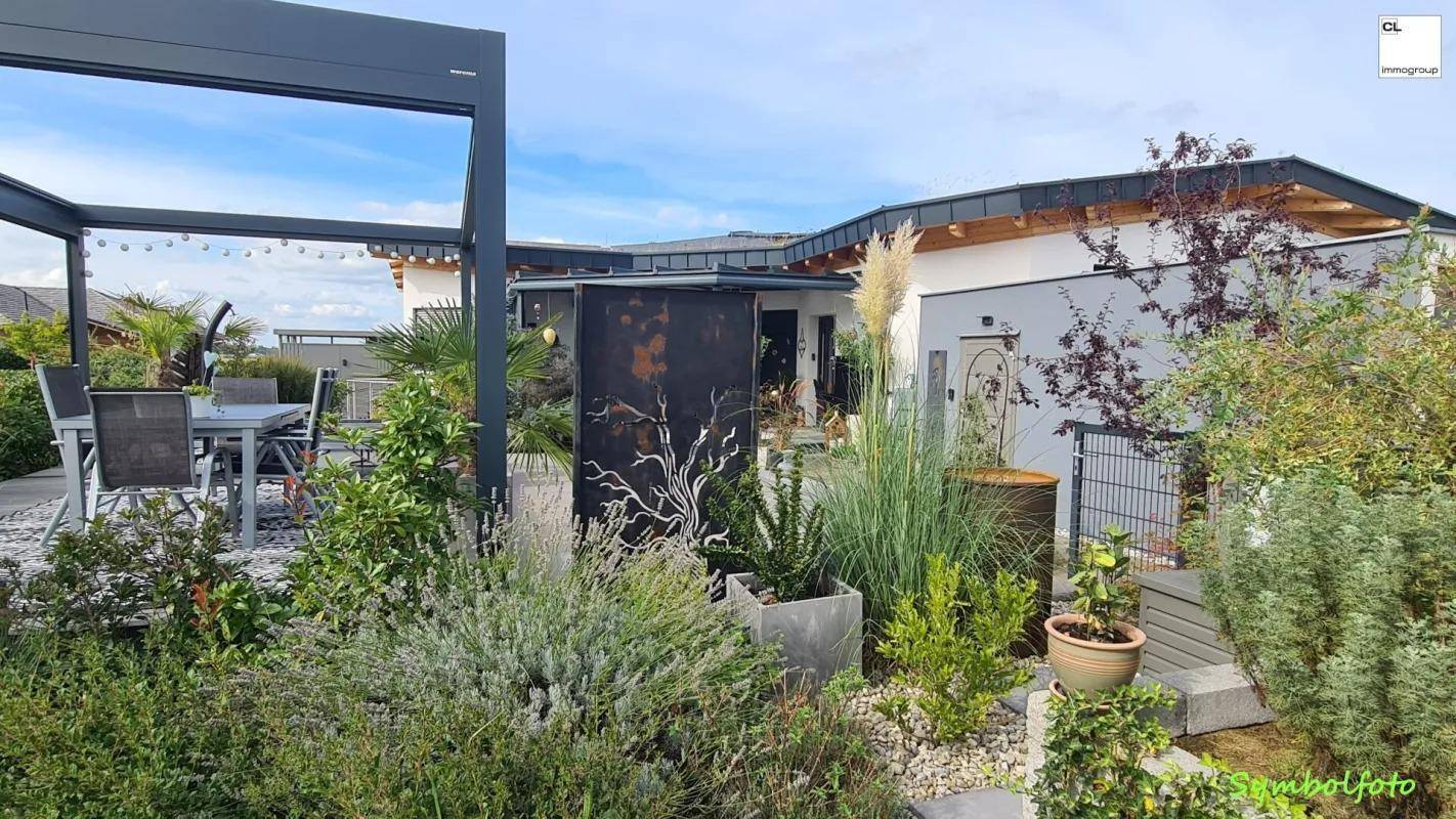 Gepflegter Gartenbereich mit vielfältiger Bepflanzung und einem Blick auf die angrenzende Terrasse.
