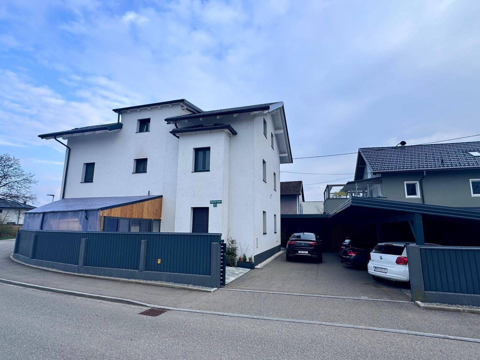 Ansicht des modernen Wohnhauses mit Einfahrt und Carport von der Straßenseite.
