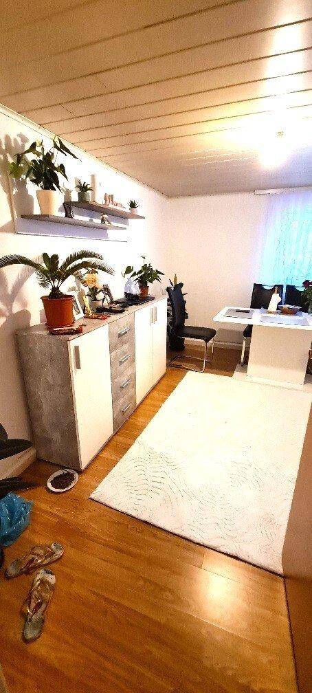 Heller Wohn-/Essbereich mit Parkettboden, Sideboard und Esstisch, offen gestaltet.