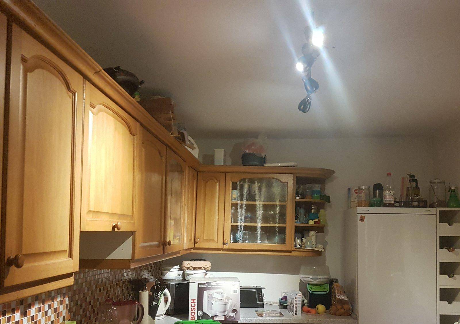 Rustikale Küche mit Holzschränken, Fliesenrückwand und Kühlschrank.