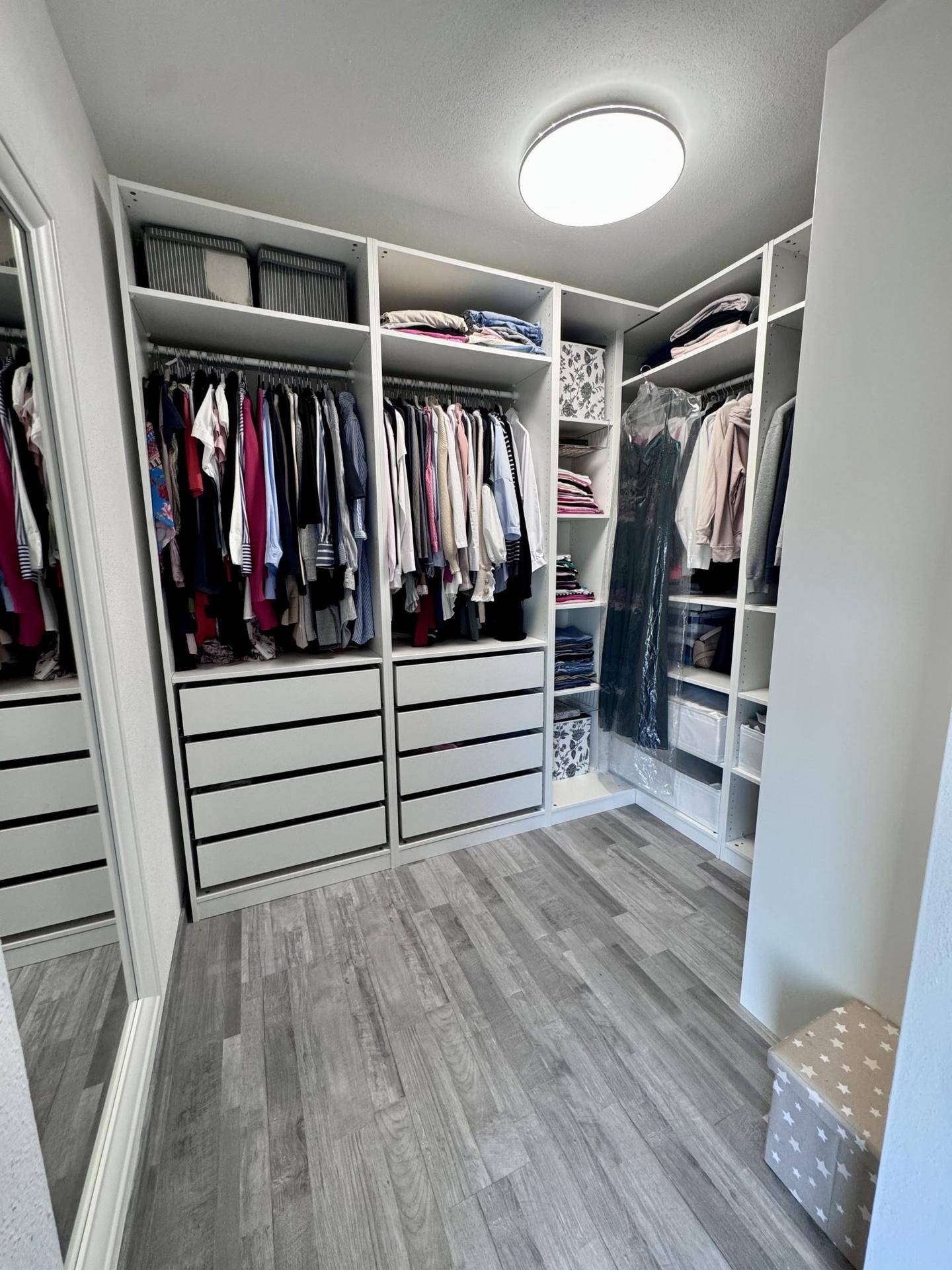 Geräumiger begehbarer Kleiderschrank mit viel Stauraum und Regalsystemen.
