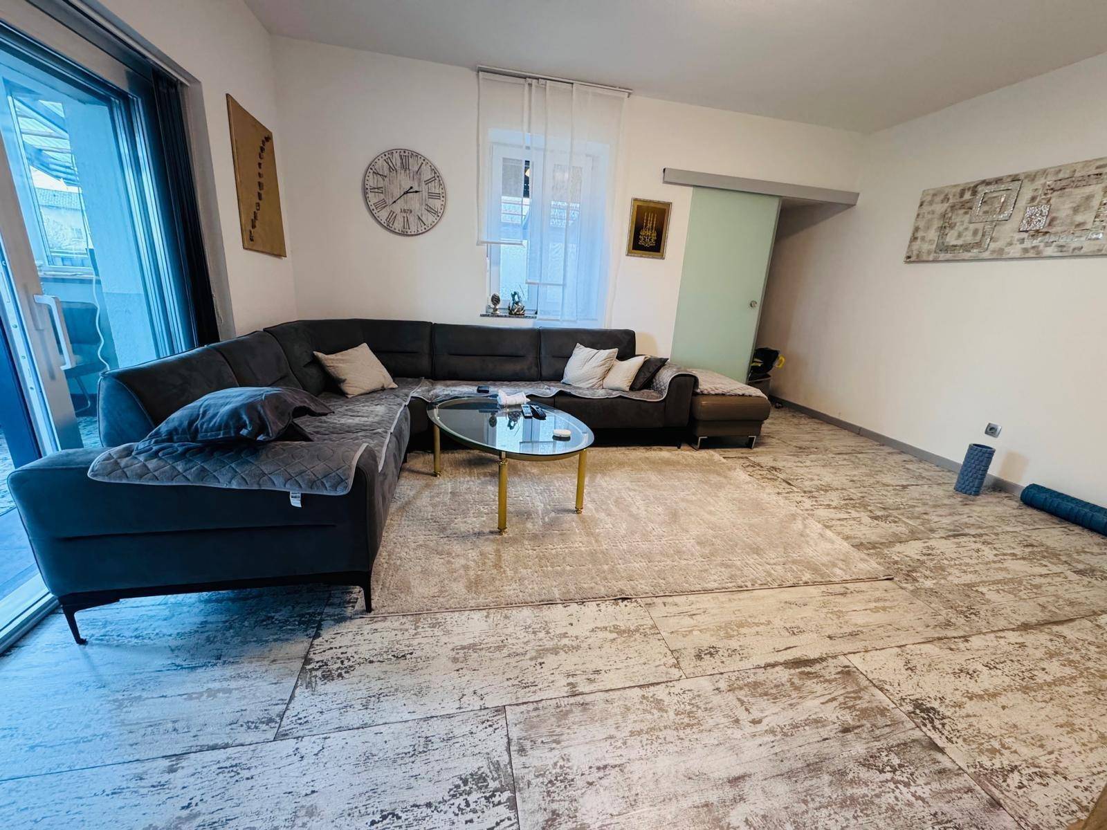 Helles Wohnzimmer mit gemütlichem Ecksofa und modernem Couchtisch, Blick zum Fenster.