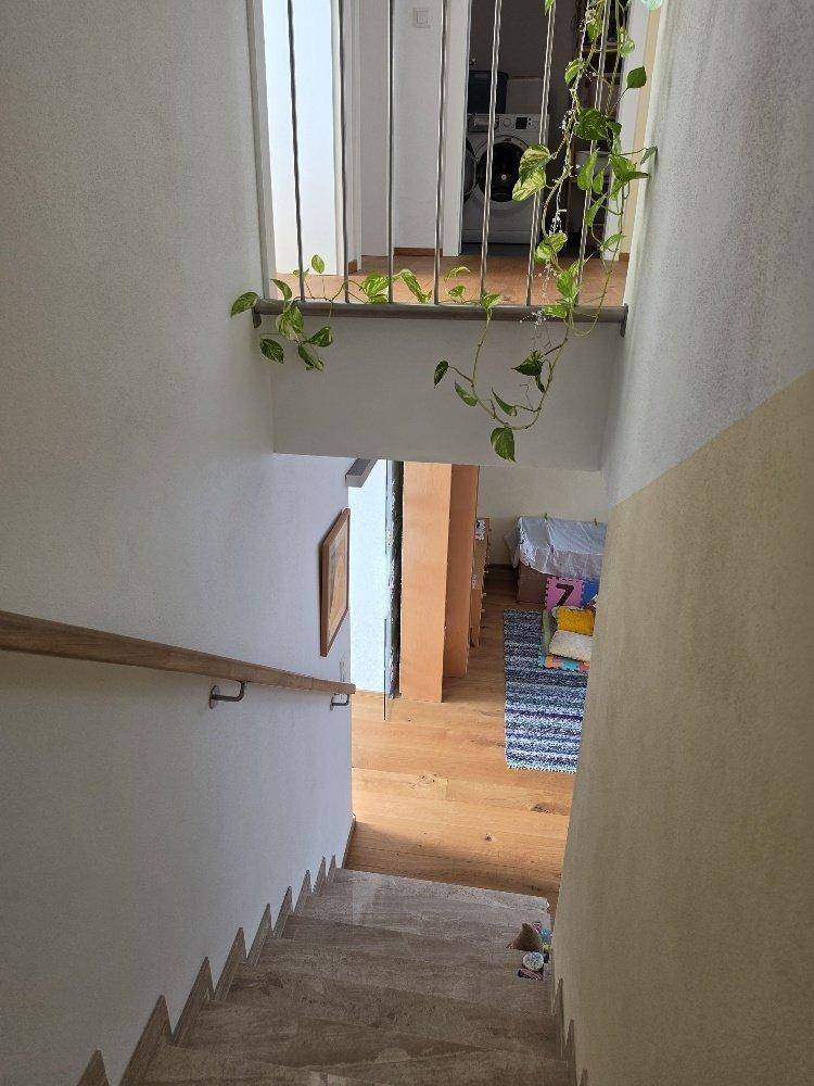 Blick von der oberen Etage auf die Marmortreppe und den darunterliegenden Wohnbereich.