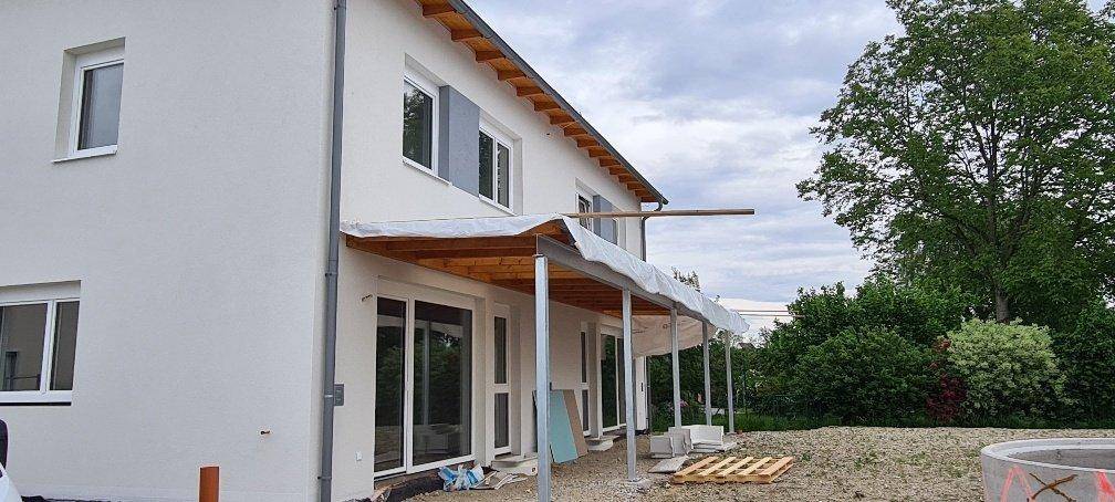 Rückseite des Neubaus mit im Bau befindlicher überdachter Terrasse und Zugang zum Gartenbereich.