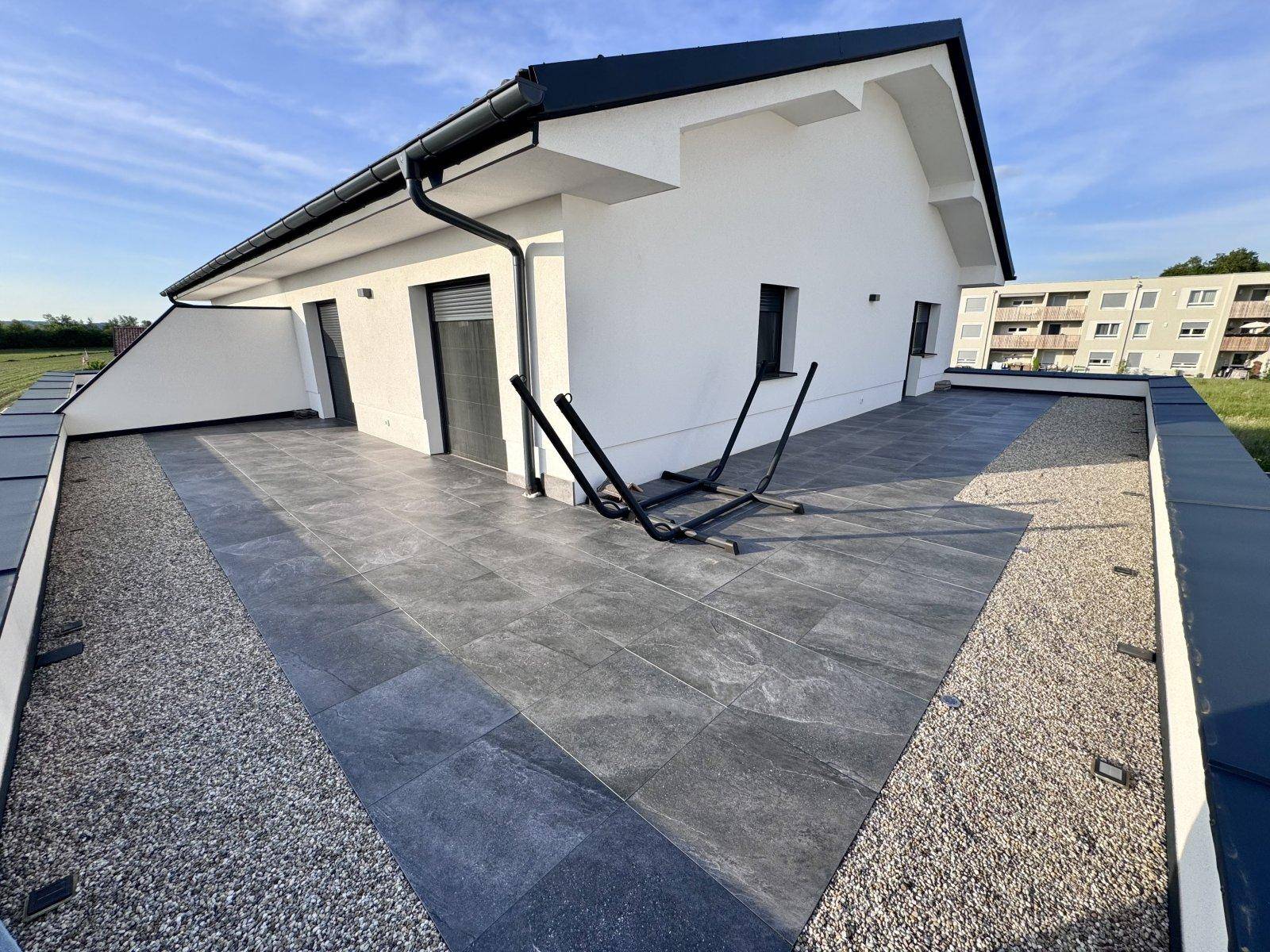 Große, geflieste Terrasse am Haus mit Blick auf die umliegende Landschaft.