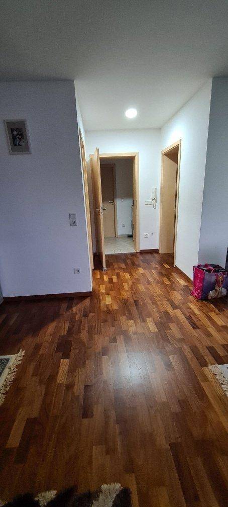 Heller Flur mit Holzboden und mehreren Türen, die zu anderen Räumen führen.