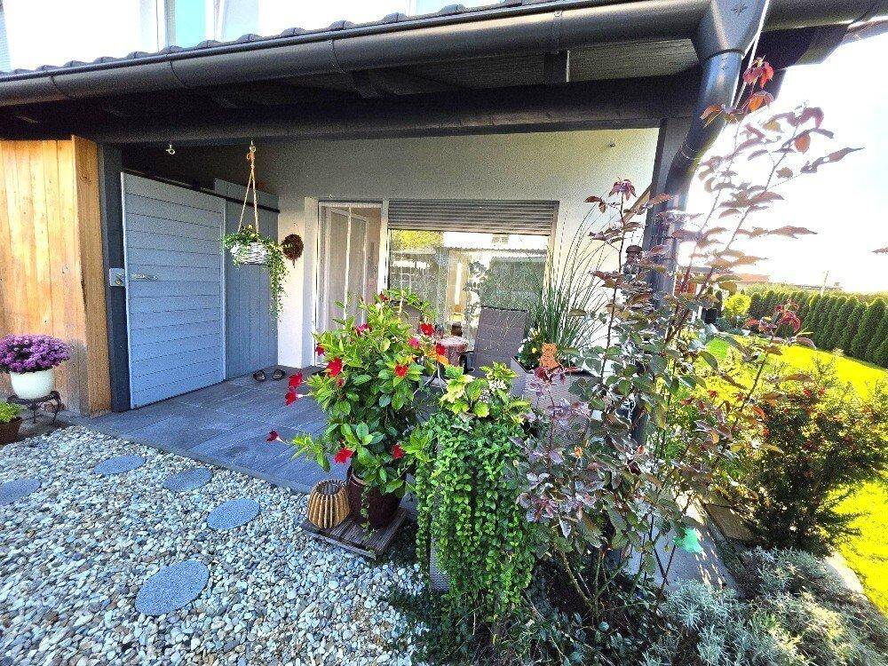 Gemütliche Terrasse mit Pflanzen, Kiesbeet und Sitzgelegenheiten, ideal zum Entspannen im Freien.