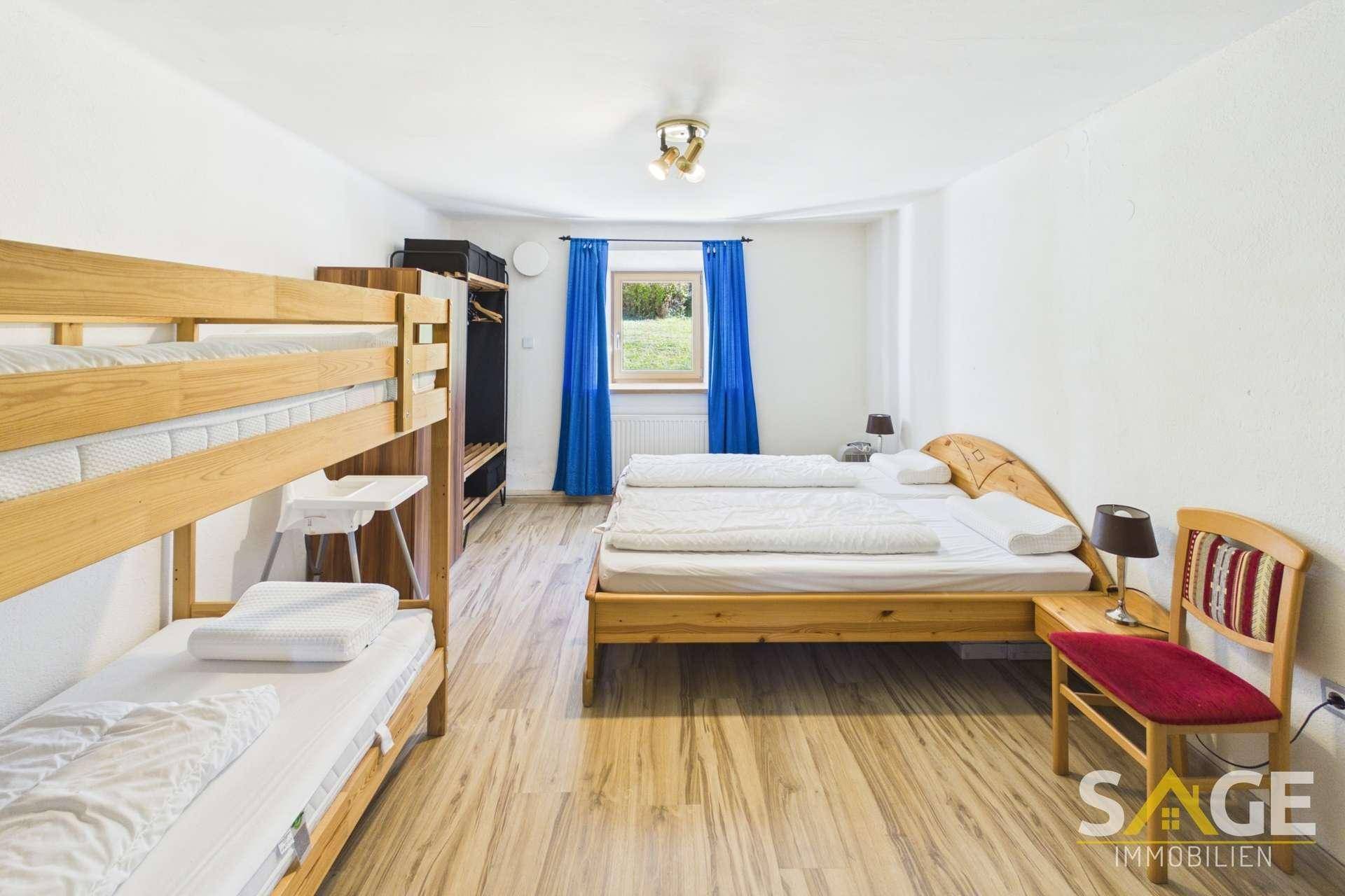 Geräumiges Schlafzimmer mit Doppelbett, Etagenbett und Blick ins Grüne.