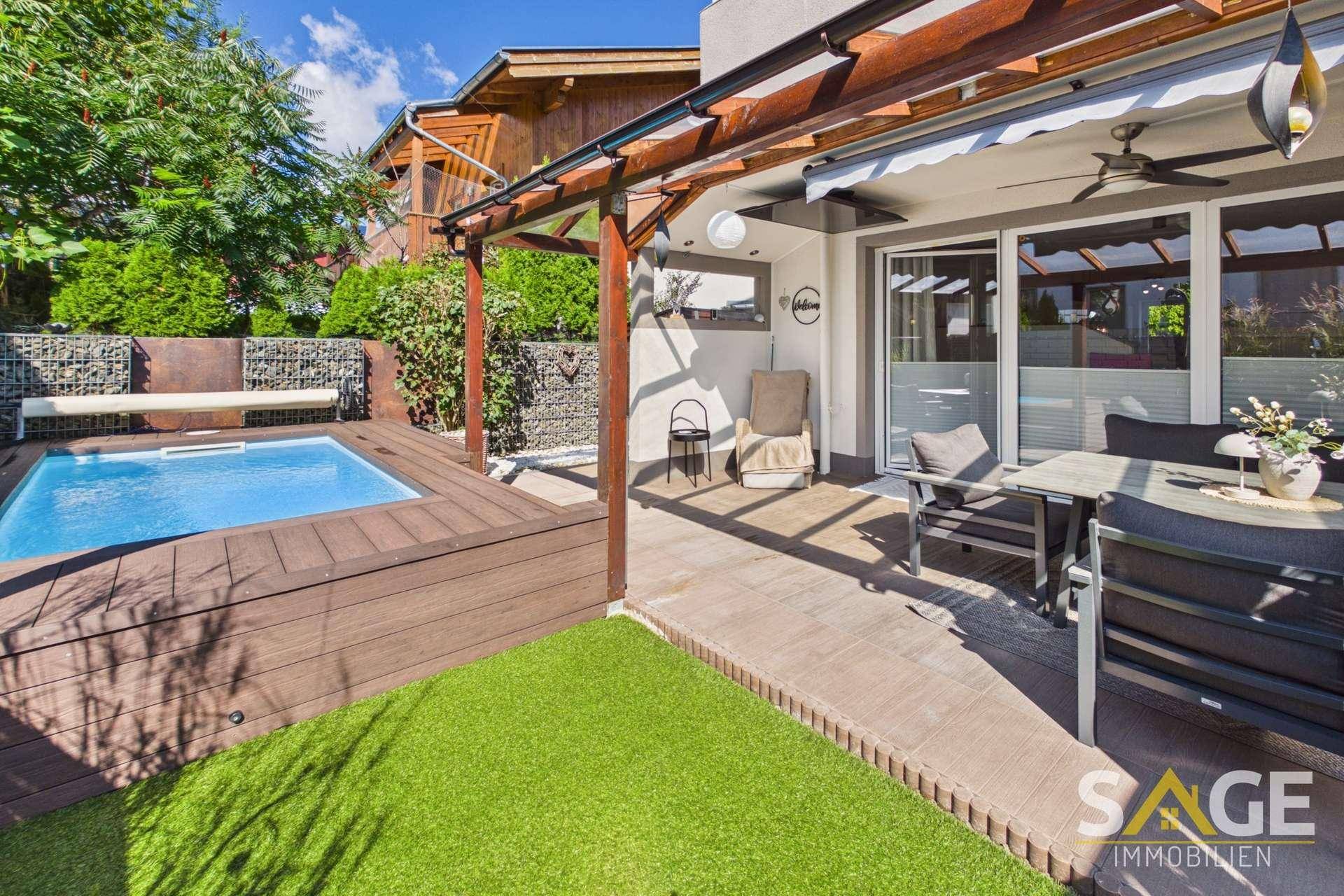 Sonnige Terrasse mit kleinem Pool, Holzdeck, Pergola und gemütlichem Essbereich im Freien.