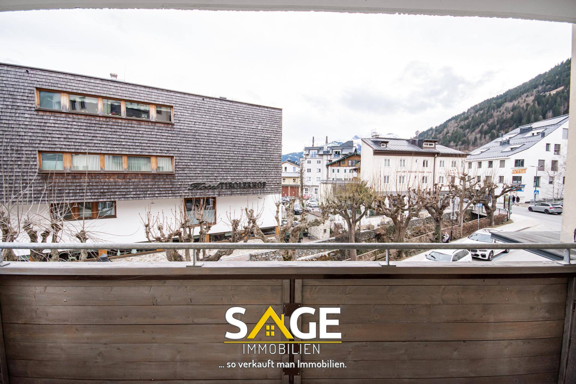 Blick vom Balkon auf die umliegenden Gebäude und die ruhige Straße mit kahlen Bäumen.