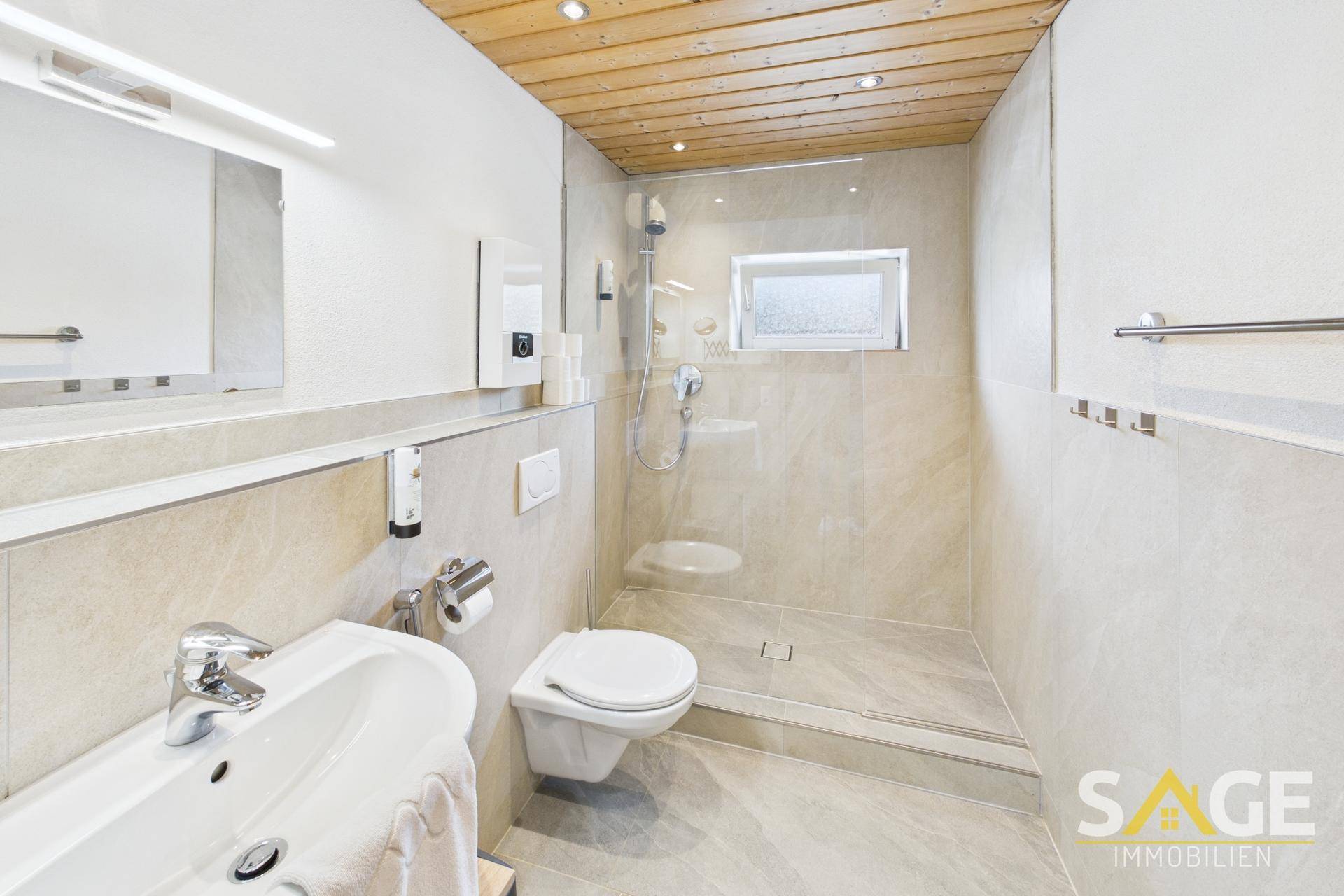 Modernes Badezimmer mit begehbarer Dusche, Wand-WC und Holzdecke.