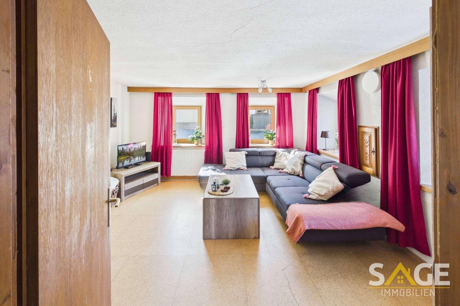 Geräumiges Wohnzimmer mit bequemer Sitzecke und Blick auf die umliegende Landschaft.
