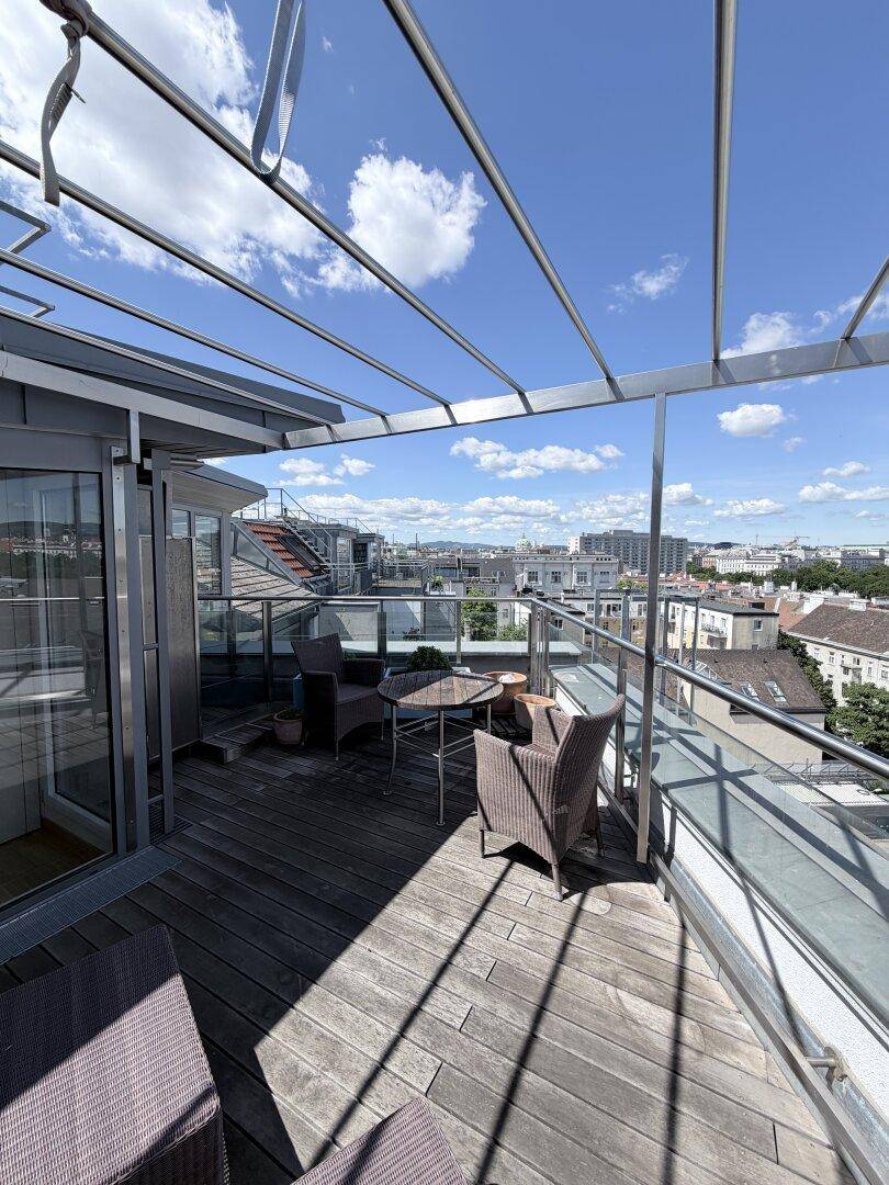 Sonniger Bereich der Dachterrasse mit Sitzgelegenheiten und weitem Stadtblick.