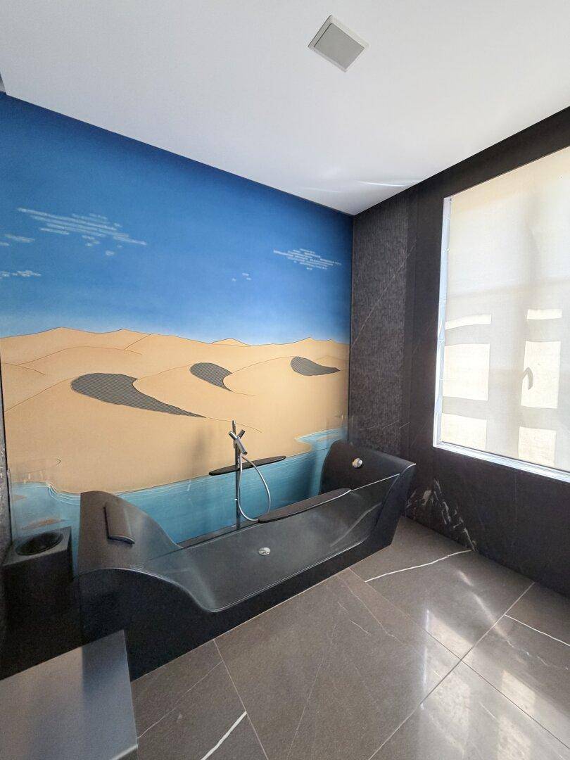 Luxuriöses Badezimmer mit freistehender Badewanne und Wandgemälde.