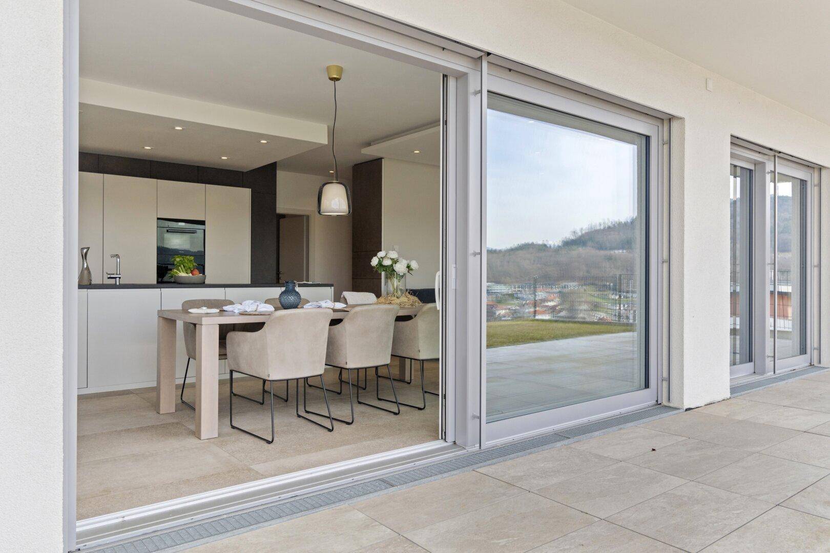 Helle Terrasse mit Blick auf die Landschaft und direktem Zugang zum Essbereich.