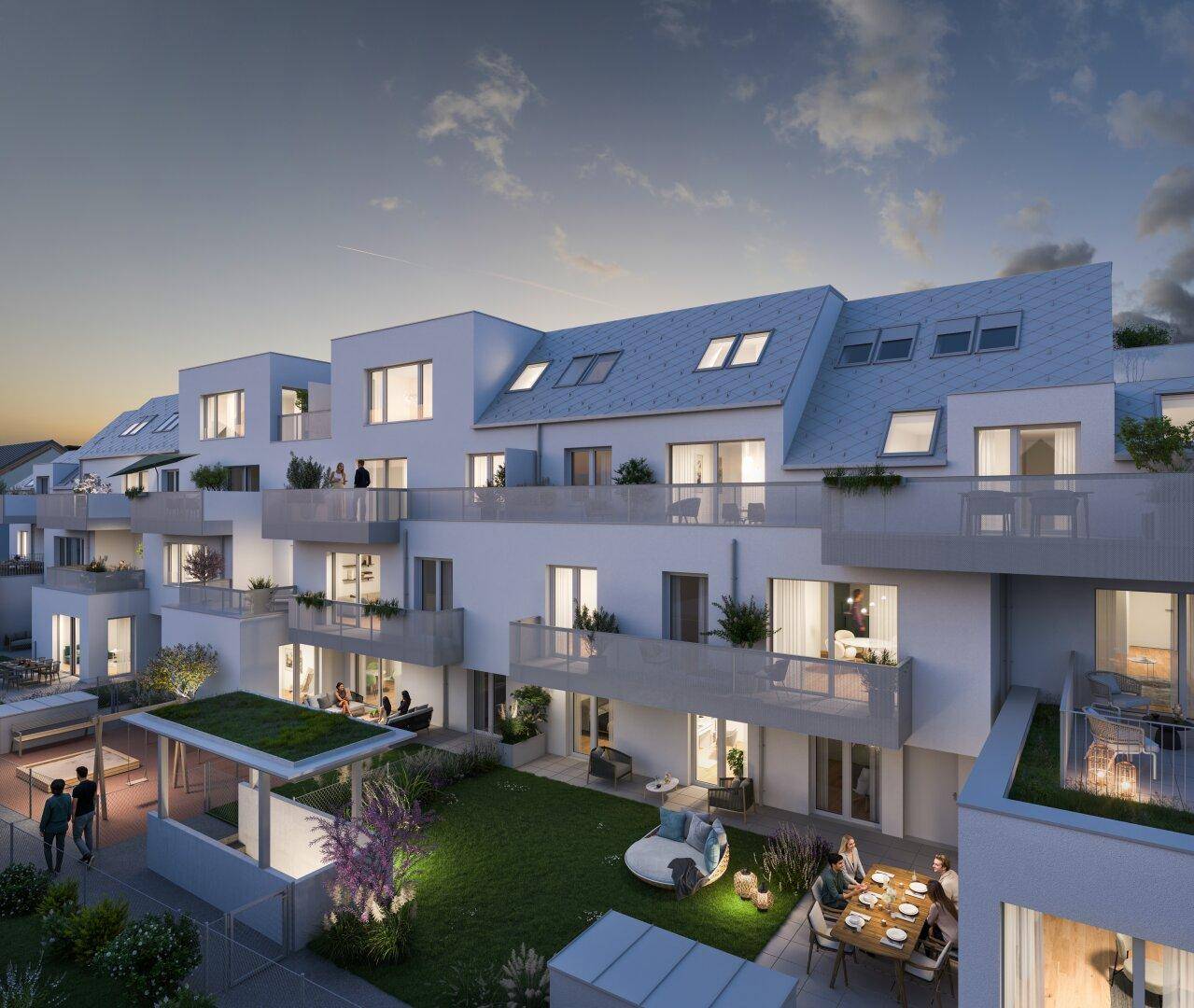 Abendliche Ansicht einer modernen Wohnanlage mit beleuchteten Balkonen und Gemeinschaftsgarten.