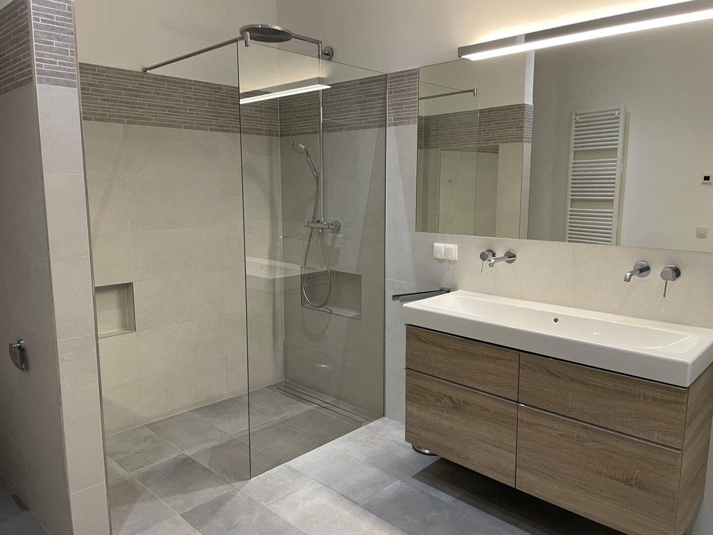 Modernes Badezimmer mit großer begehbarer Dusche und Doppelwaschbecken.