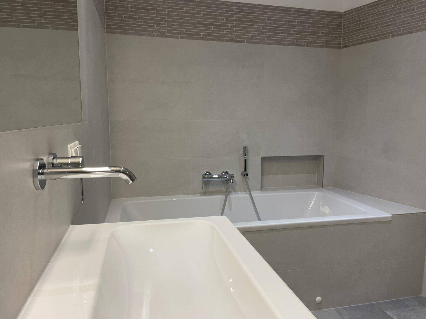 Elegantes Badezimmer mit integrierter Badewanne und modernem Waschbecken.