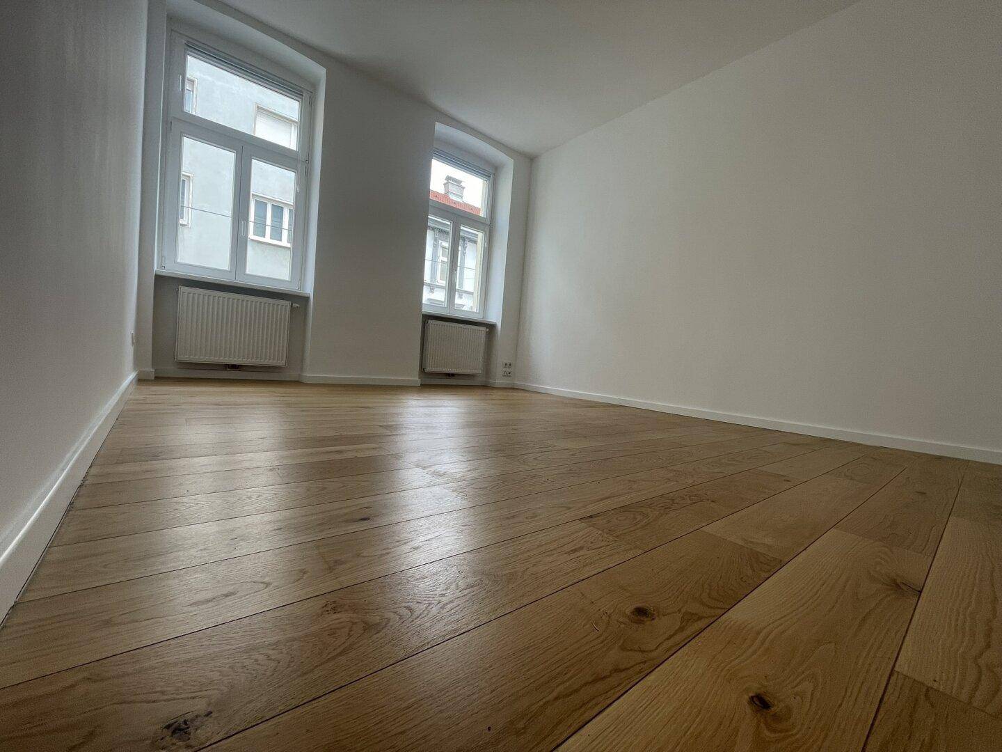 Detailansicht des hochwertigen Parkettbodens in einem hellen Zimmer.