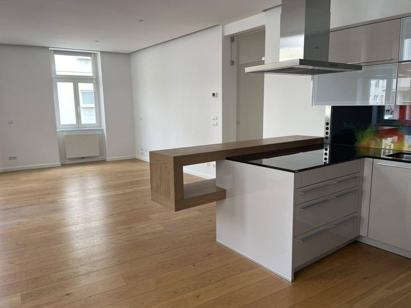 Offener Wohnbereich mit integrierter Küche, Kochinsel und Induktionskochfeld.