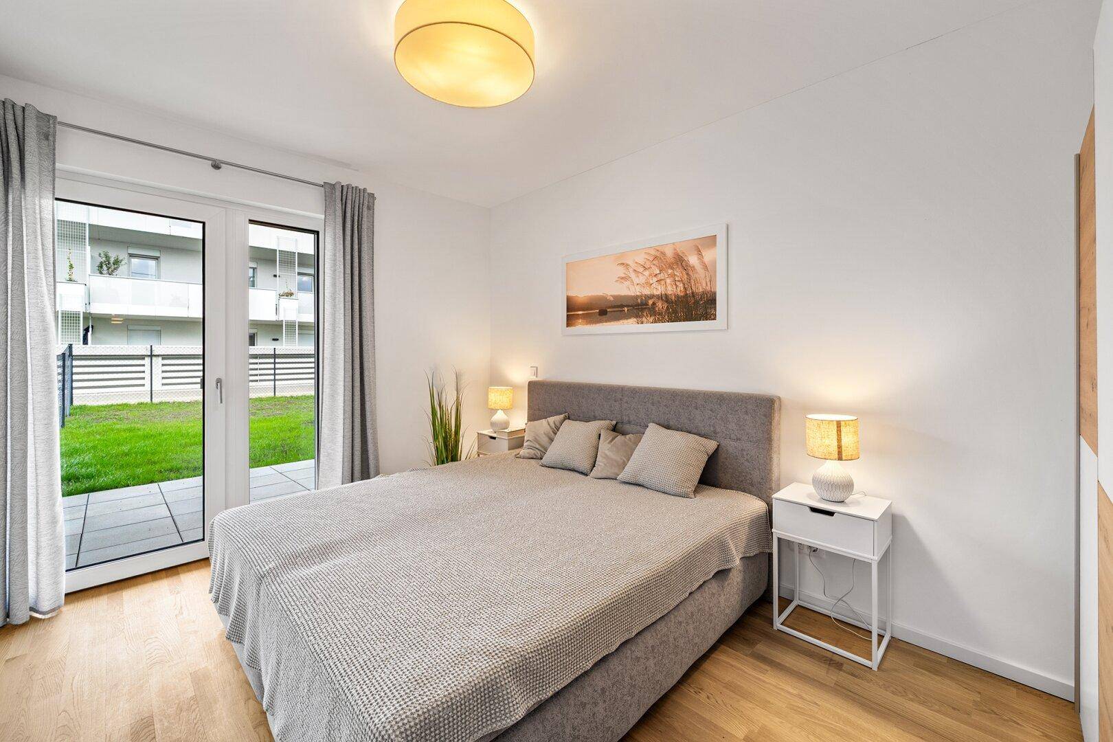 Gemütliches Schlafzimmer mit Doppelbett, Holzboden und direktem Gartenzugang.