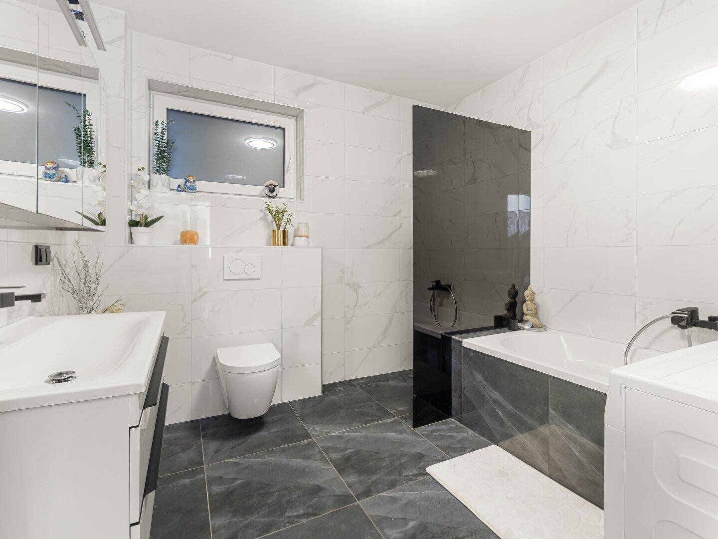 Modernes Badezimmer mit Marmorfliesen, Badewanne und separater Dusche.