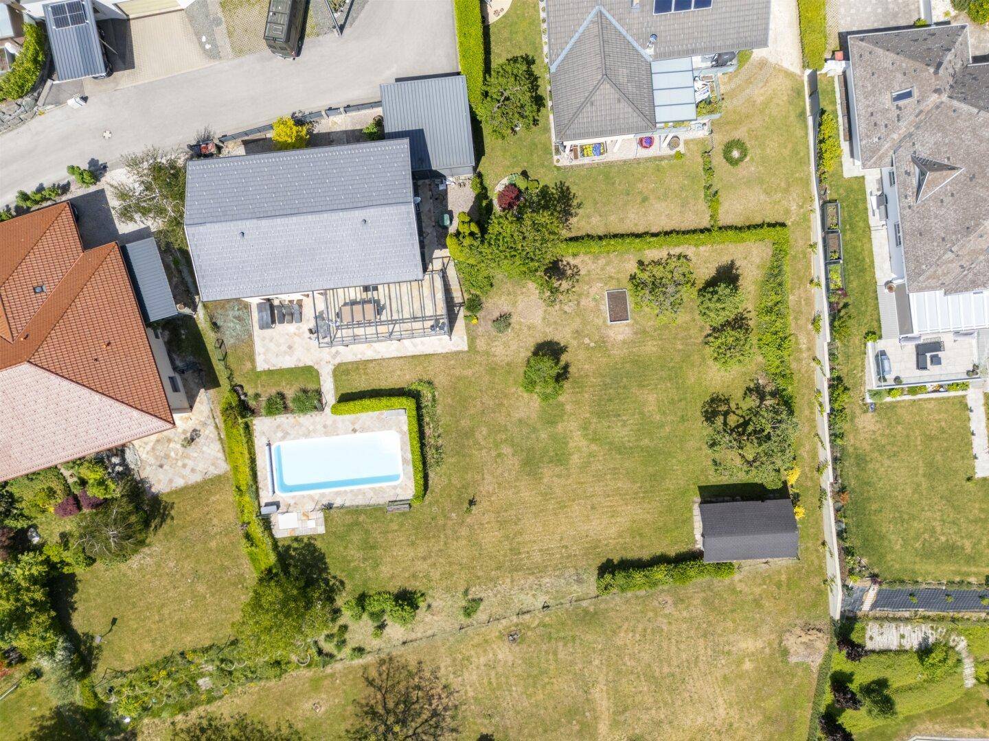 Luftaufnahme des Anwesens mit großem Garten, Pool und Nebengebäude.