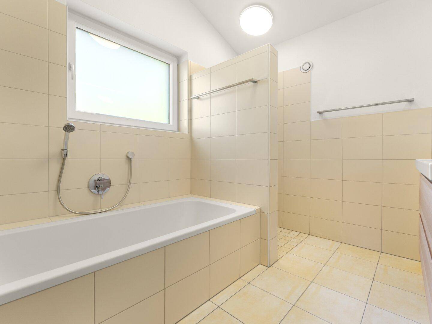Helles Badezimmer mit Badewanne, Dusche und Fenster in beigen Farbtönen.