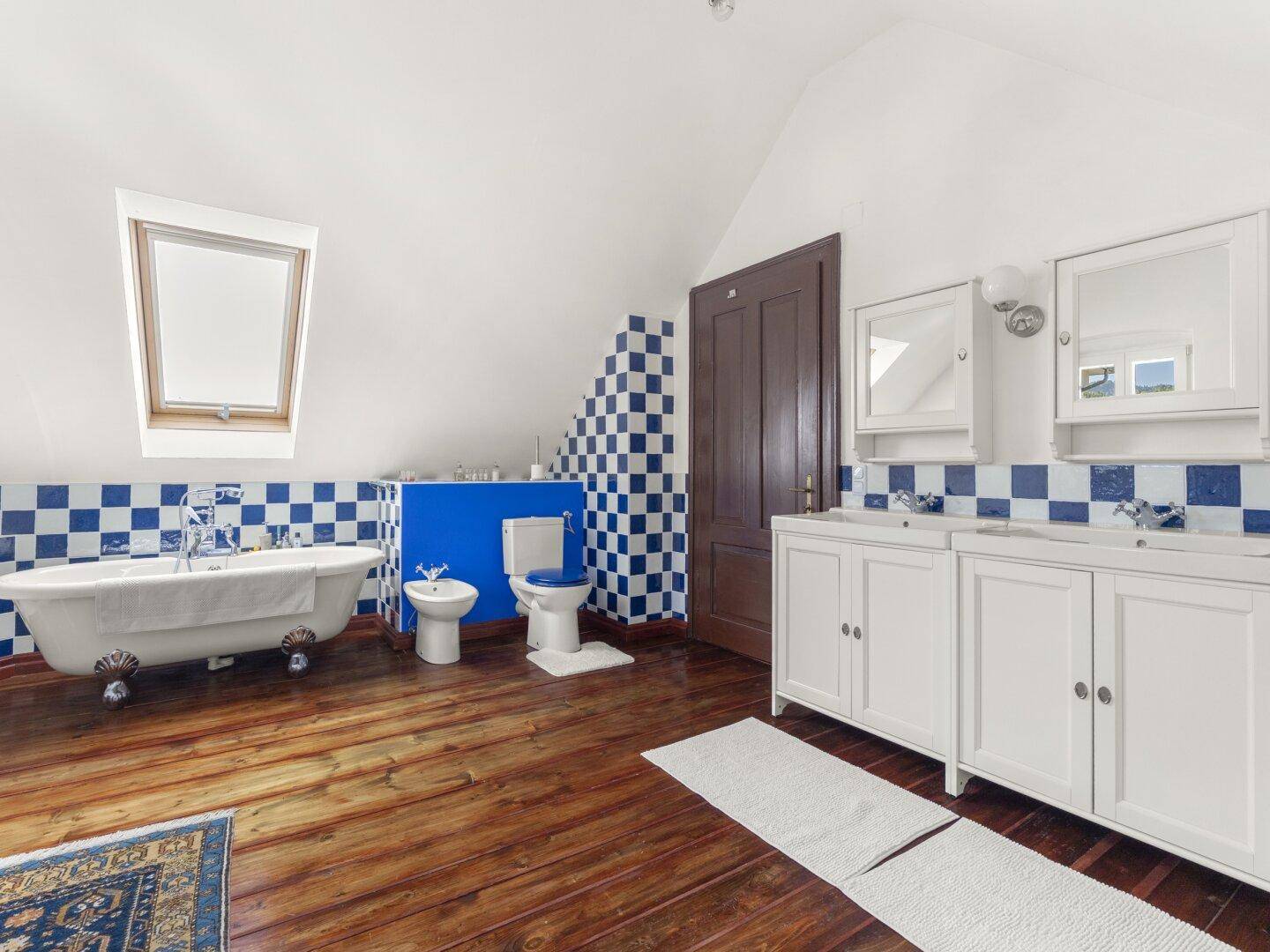 Geräumiges Badezimmer mit freistehender Badewanne, Bidet und doppelten Waschbecken.