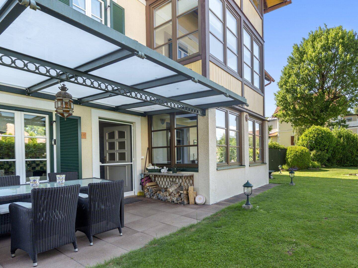Große überdachte Terrasse mit Zugang zum Garten und Blick ins Grüne.