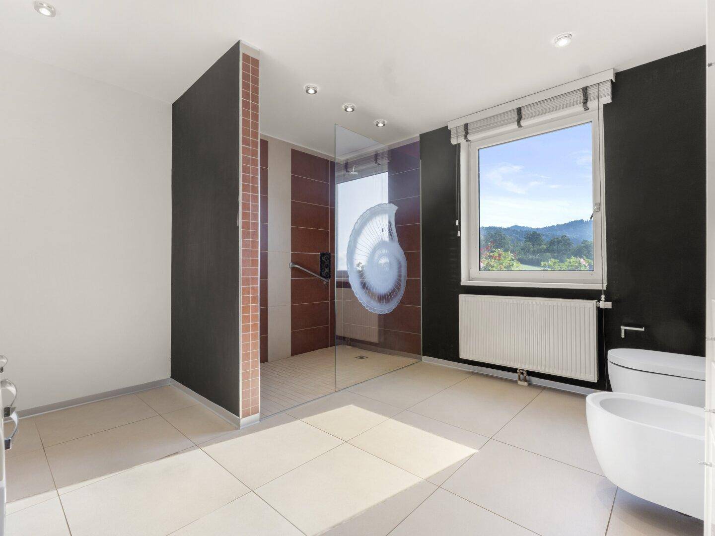 Modernes Badezimmer mit großer begehbarer Dusche, Bidet und Fenster mit Weitblick.